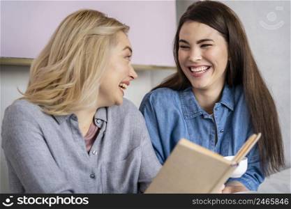 happy laughing women having coffee reading book