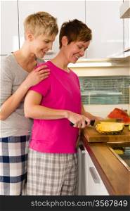 Happy lesbian couple making a breakfast in the kitchen, vertical format