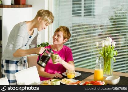 Happy lesbian couple on the breakfast table