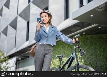 Happy lifestyle business female commuting outside in morning, Asian smiling young woman use smart mobile phone talk with business during go to office work at city street with bicycle, Eco friendly