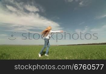 Happy little blond girl running on a spring field