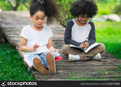 Happy little boy and girl in the park. Two African American children together in the garden.. Happy little boy and girl in the park.