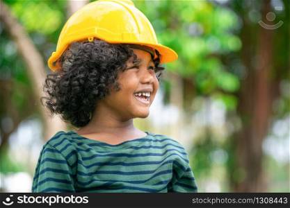 Happy little boy engineer wearing yellow safety helmet hard hat and laughing with happiness. Education and learning concept.. Happy little boy engineer wearing helmet hard hat.