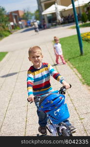 happy little boy have fun in park and learning to ride his first bike