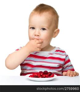 Happy little boy with strawberries, isolated over white