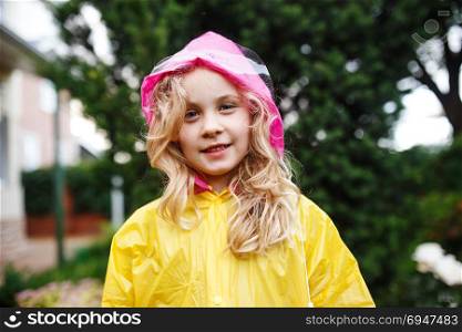 Happy little child girl in yellow raincoat.. Happy little child girl in yellow raincoat