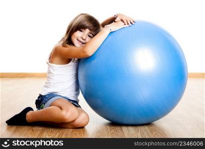 Happy little child playing with a big blue ball