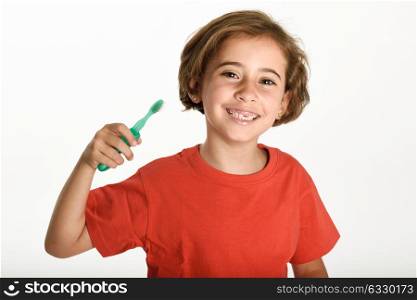 Happy little girl brushing her teeth with a toothbrush isolated on white background. Studio shot.