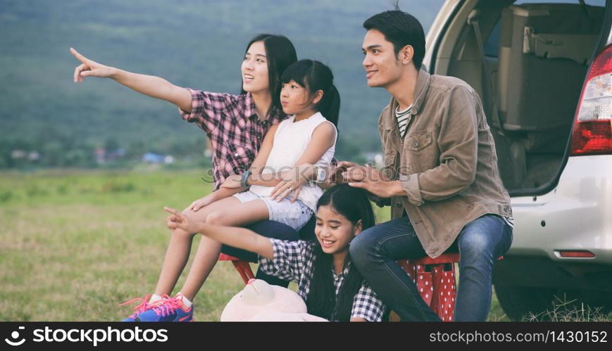 Happy little girl e with asian family sitting in the car for enjoying road trip and summer vacation in camper van