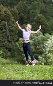 Happy little girl jumping in summer day