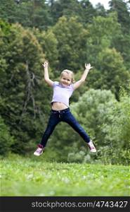 Happy little girl jumping in summer day