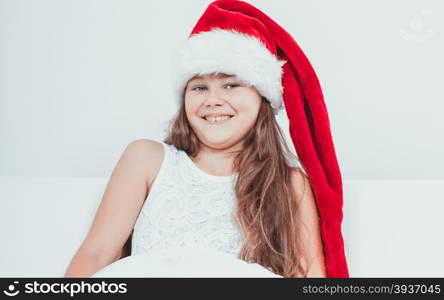 Happy little girl kid in santa hat. Christmas.. Happy cute little girl kid in red santa claus hat and white dress. Chrtistmas holiday season.