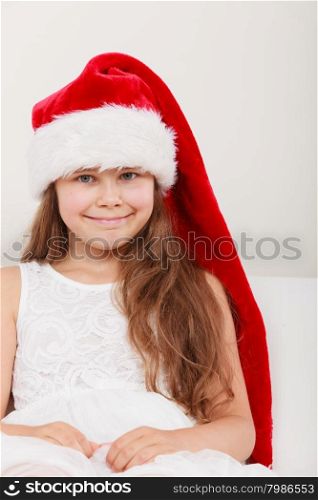 Happy little girl kid in santa hat. Christmas.. Happy cute little girl kid in red santa claus hat and white dress. Chrtistmas holiday season.