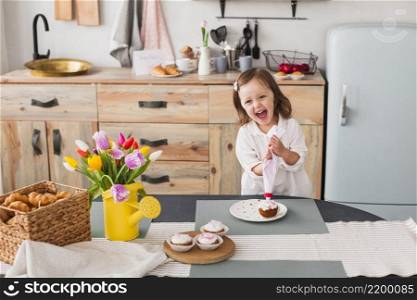 happy little girl making cupcake
