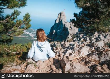 Happy little girl on edge of cliff enjoy the view on mountain top rock. Little kid on edge of cliff in mountains