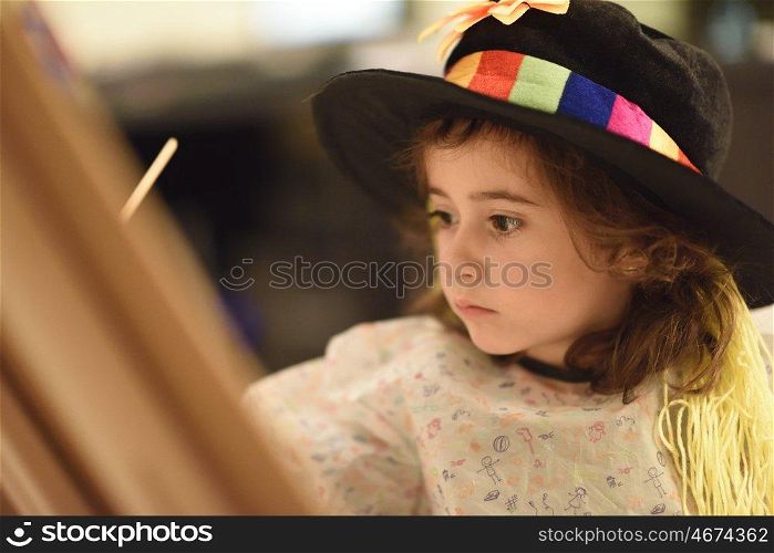 Happy little girl painting a picture at home
