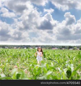 Happy little girl running through the corn field