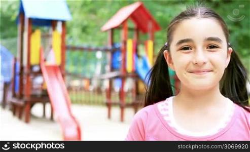 Happy little girl running to playground in summer