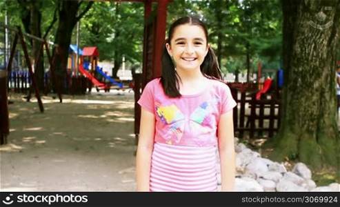 Happy little girl running to playground in summer
