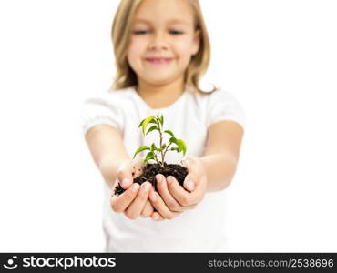 Happy little girl showing a plant on her little hands