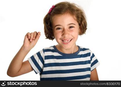 Happy little girl showing her first fallen tooth. Smiling little woman with a incisor in her hand. Isolates on white background. Studio shot.