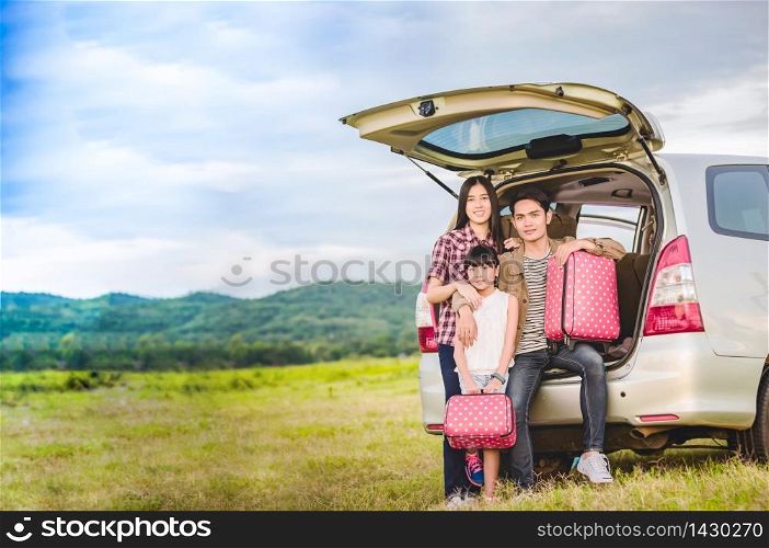 Happy little girl with asian family sitting in the car for enjoying road trip and summer vacation in camper van