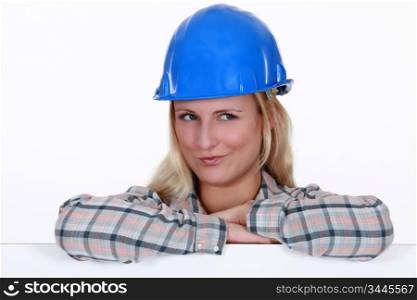 happy-looking blonde craftswoman with arms resting on board