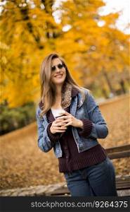 Happy lovely young longhair woman drinking outdoor coffee in autumn park