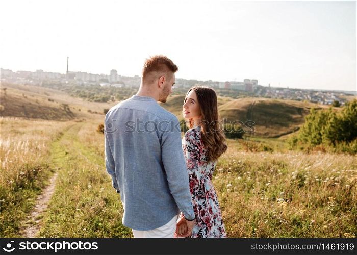 happy loving couple on the mountain. Happy couple faces skyline at city. Top view point overlooking the mountains. holidays, vacation, love and friendship concept.. happy loving couple on the mountain. Happy couple faces skyline at city. Top view point overlooking the mountains. holidays, vacation, love and friendship concept