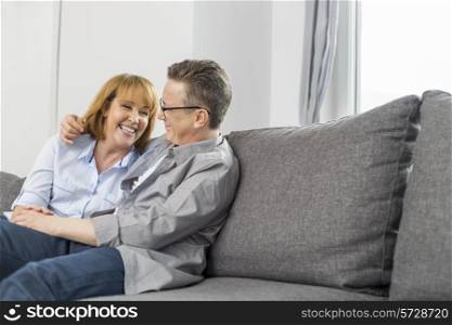 Happy loving couple sitting on sofa at home