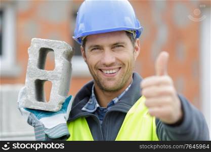 happy male builder showing thumb up