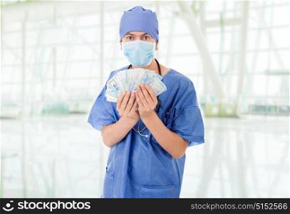 Happy male doctor holding bank notes, at the hospital