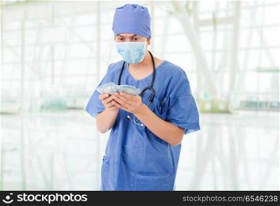 Happy male doctor holding bank notes, at the hospital. doctor