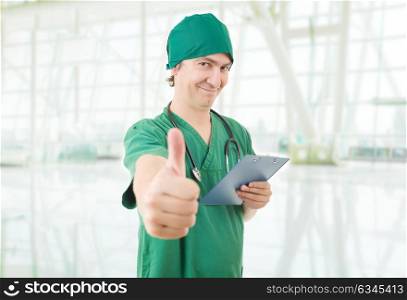 Happy male doctor showing thumbs up at the hospital