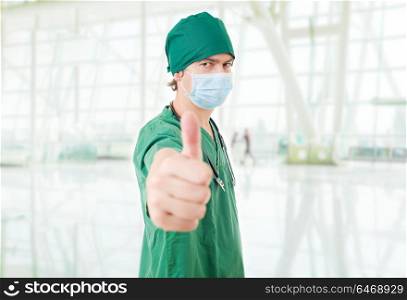 Happy male doctor showing thumbs up, at the hospital