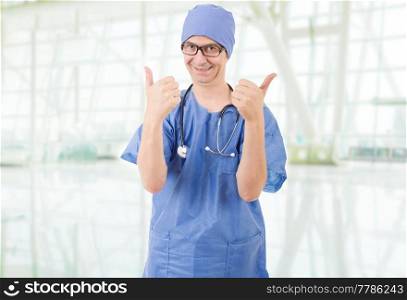 Happy male doctor showing thumbs up, at the hospital