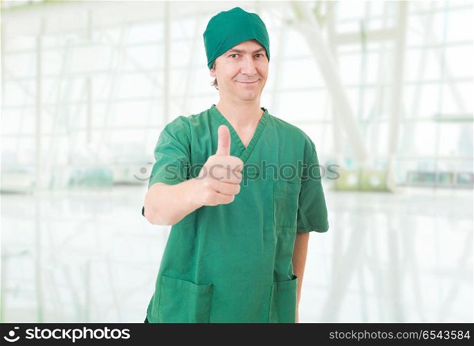 Happy male doctor showing thumbs up at the hospital. thumbs up