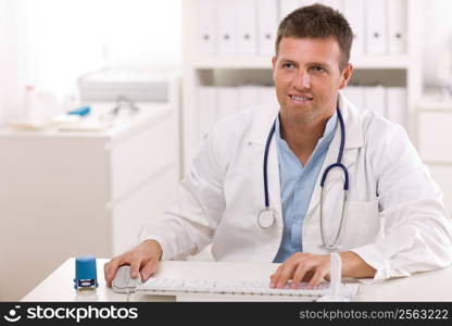 Happy male doctor working at office, smiling.