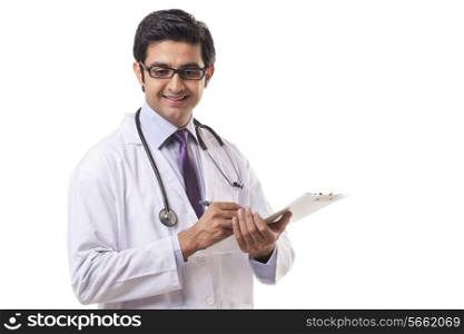 Happy male doctor writing on clipboard over white background
