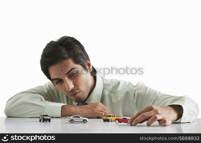 Happy male executive playing with model car