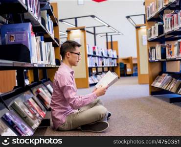 Happy male student holding books at the library. Happy male asian student holding books at the library