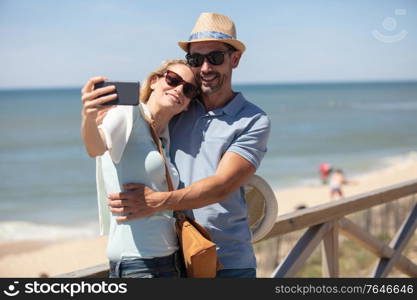 happy man and beautiful woman taking selfie photo