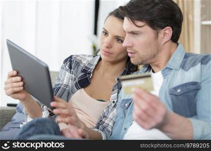 happy man and his pregnant wife with tablet pc computer