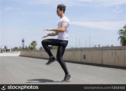 Happy man and jumping outdoors, warmup before jogging