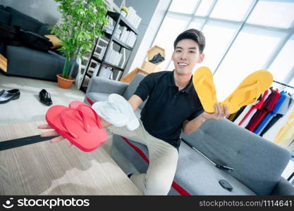 Happy man at home speaking in front of camera for vlog. Young Asian man working as blogger, recording video tutorial for Internet
