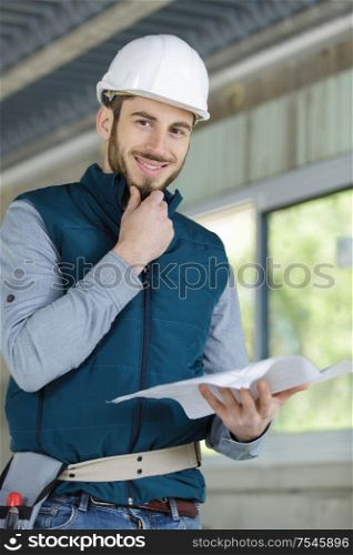 happy man builder holding drawing