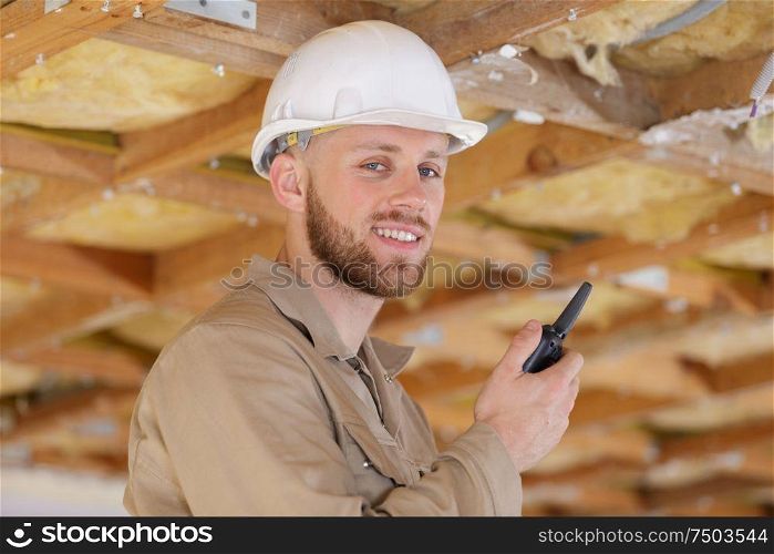happy man-builder using a walkie-talkie in his hands