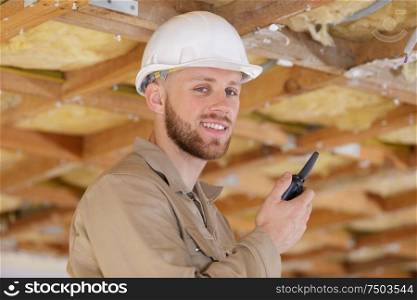 happy man-builder using a walkie-talkie in his hands