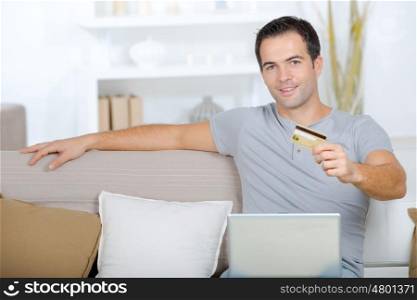 happy man buying online in his living room