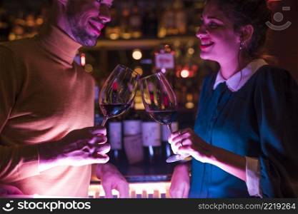 happy man clanging glasses wine with cheerful woman